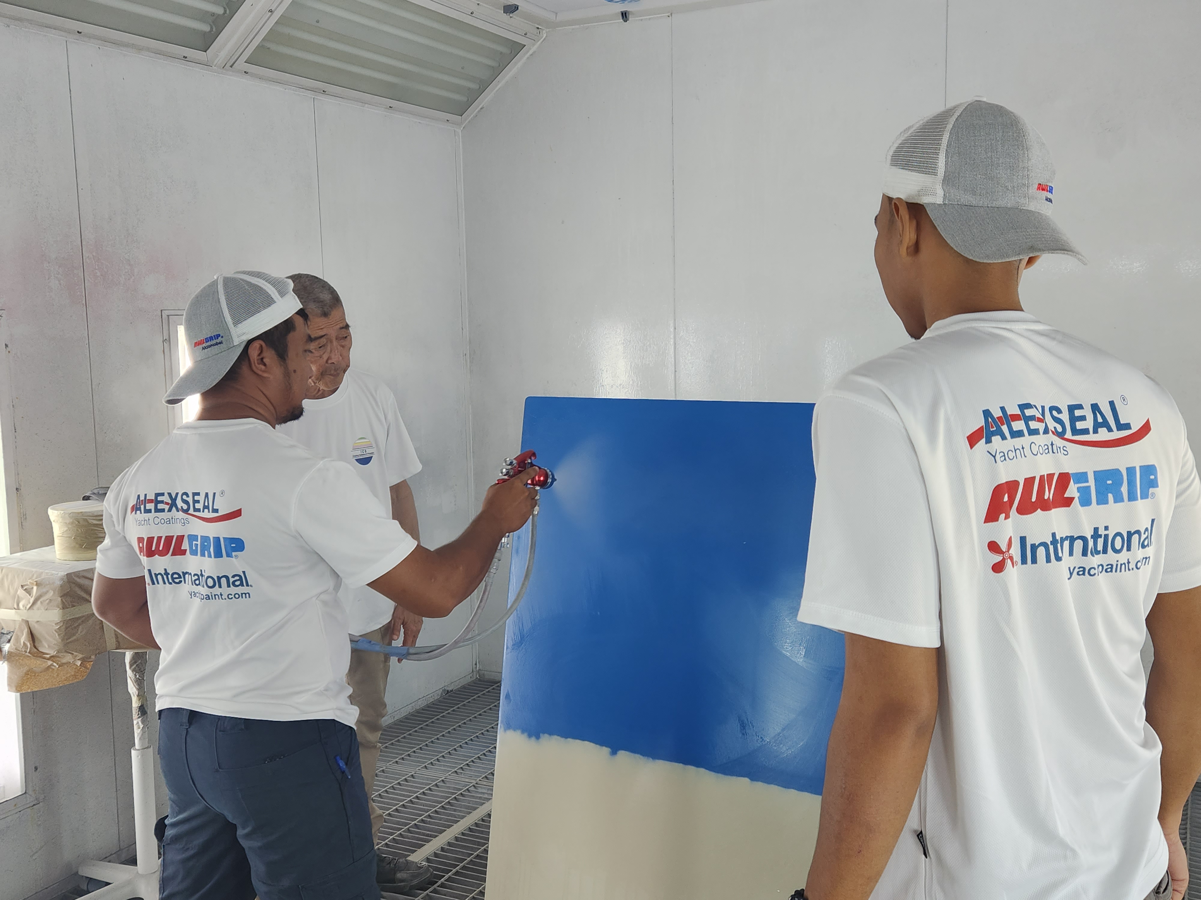 ICS painters applying blue coating on a practice panel